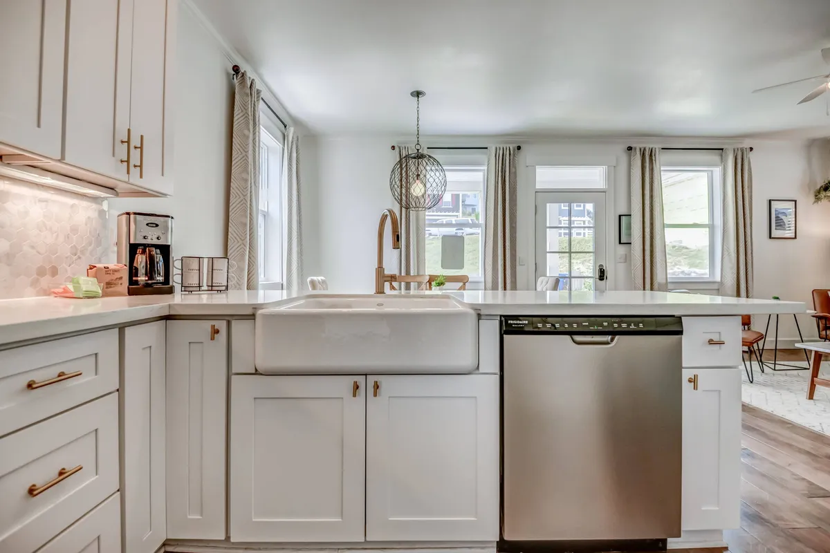 A bright, inviting kitchen with a farmhouse sink, kitchen island, and abundant natural light. The space encourages cooking, entertaining, and social gatherings, echoing the home’s 'chef-ready' amenities.